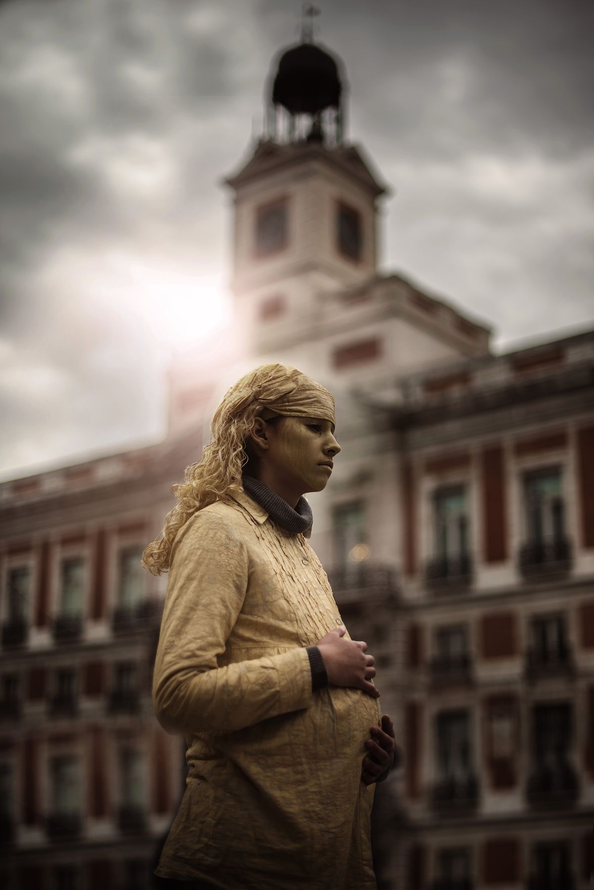 In my trip to Madrid i saw this living statue on a place call "sol" that means "sun" and the sun itself was just behind her  giving to the golden paint a glow that t makes her shine like if she was part of it , besides she was pregnant and in Spanish "give birth" is translated something like "dar a luz"  (giving light)  so everything matched for the picture. I took a very low position to get a good perspective of the sun and give rid of all the people who was around, in the processing i just cloned on some heads and give more emphasis to the light with a warm filter. It's one of my favorites pictures of that trip.